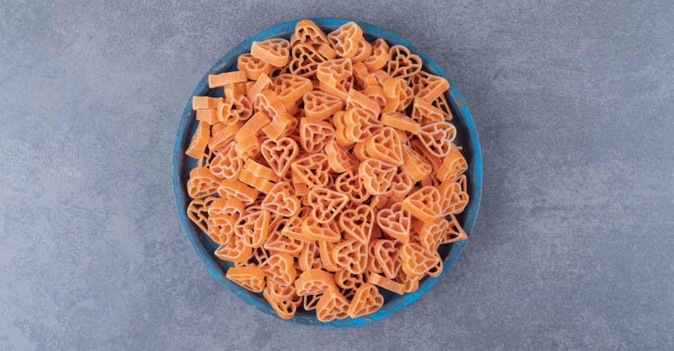 Pile of heart-shaped pasta on blue plate. High quality photo